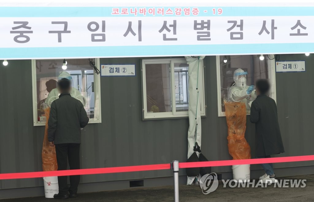 People receive coronavirus tests at a makeshift clinic in front of Seoul Station on March 26, 2021. (Yonhap)