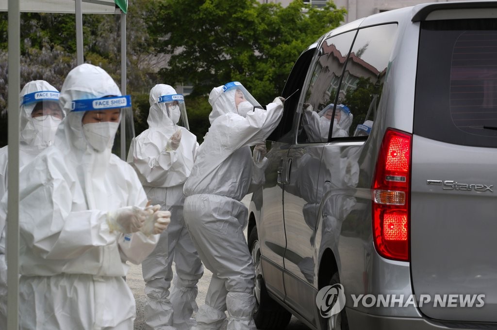 Medical workers conduct COVID-19 tests at a drive-thru screening station in Damyang, 344 kilometers south of Seoul, on April 16, 2021. (Yonhap)
