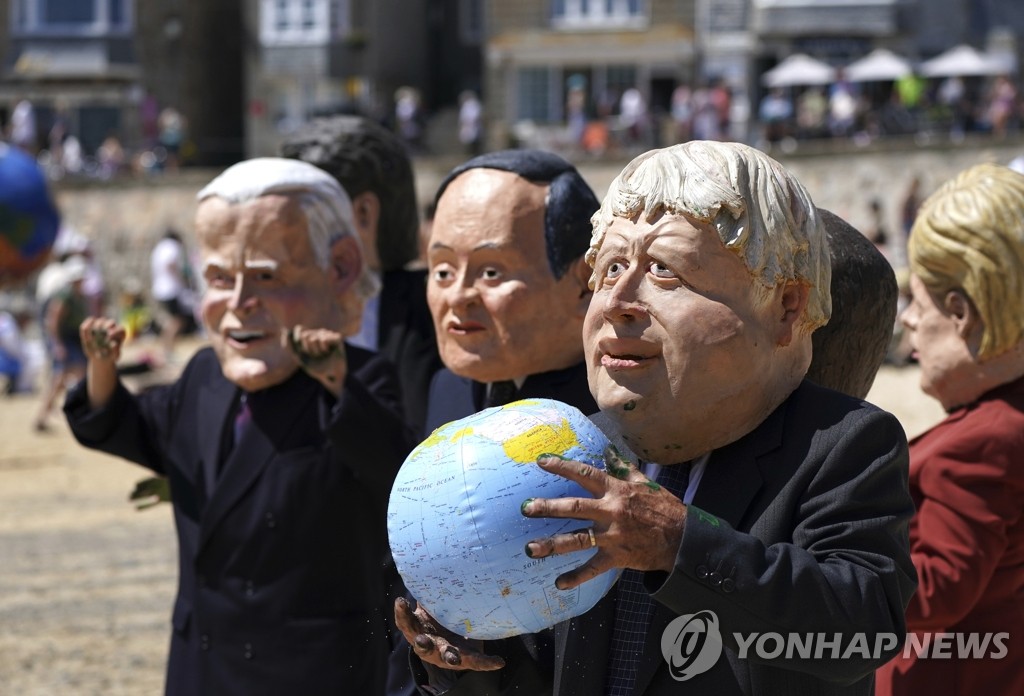 G7 정상회의장 밖에서 가면 쓰고 지구본 든 시위대
