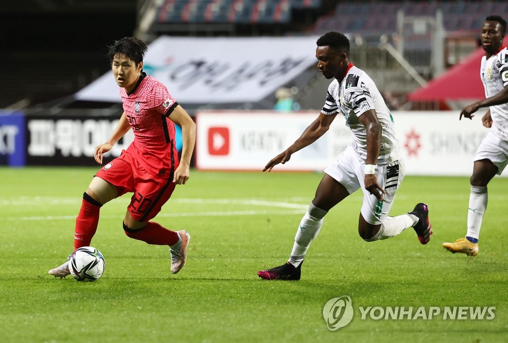 In this file photo from June 15, 2021, Lee Kang-in (L) of the South Korean men's Olympic football team dribbles past Sabit Abdulai of Ghana during a friendly match at Jeju World Cup Stadium in Seogwipo, Jeju Island. (Yonhap)