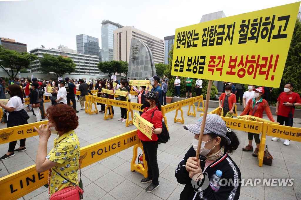 Small business owners hold a rally in central Seoul on June 18, 2021, to demand the lifting of COVID-19 business restrictions. (Yonhap)