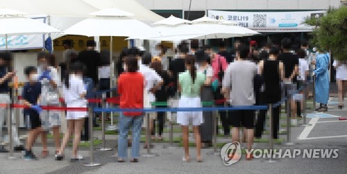 Des gens font la queue avant de se soumettre à un test de dépistage du nouveau coronavirus (Covid-19) dans le centre de dépistage à Gangnam à Séoul, le vendredi 30 juillet 2021.
