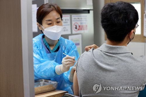 Une personne se fait vacciner contre le nouveau coronavirus (Covid-19) à l'hôpital Hong Ik à Yangcheon, dans l'ouest de Séoul, le jeudi 26 août 2021, alors que la vaccination sur les personnes de 18-49 ans a débuté le même jour.