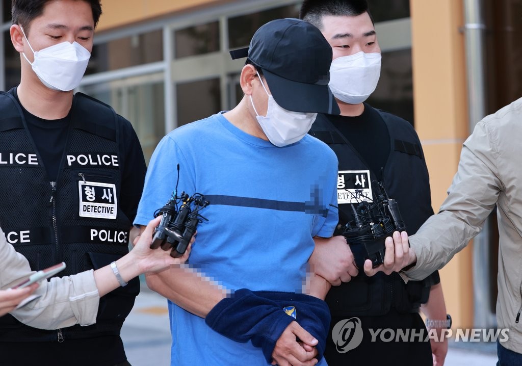 In this file photo, a man, surnamed Jang, is transferred to the prosecution on Sept. 10, 2021, for investigations on charges of stabbing his wife to death with a sword. (Yonhap)