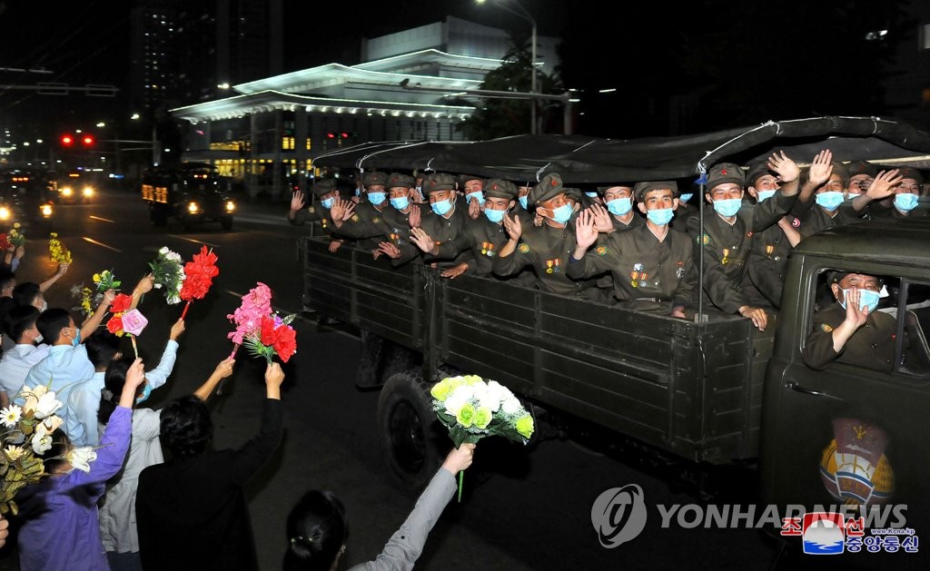 평양시민들에게 손흔드는 열병식 참가자들