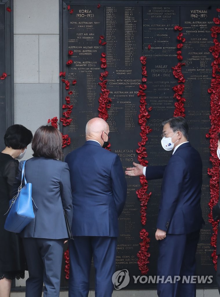 South Korean President Moon Jae-in (R) views the names of Australian soldiers killed during the 1950-53 Korean War on a cenotaph at the Australian National Korean War Memorial in Canberra on Dec. 13, 2021. (Yonhap)