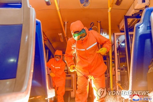 Cette photo publiée par l'Agence centrale de presse nord-coréenne (KCNA) le 3 juin 2022 montre des agents sanitaires désinfectant un tramway. (Utilisation en Corée du Sud uniquement et redistribution interdite)