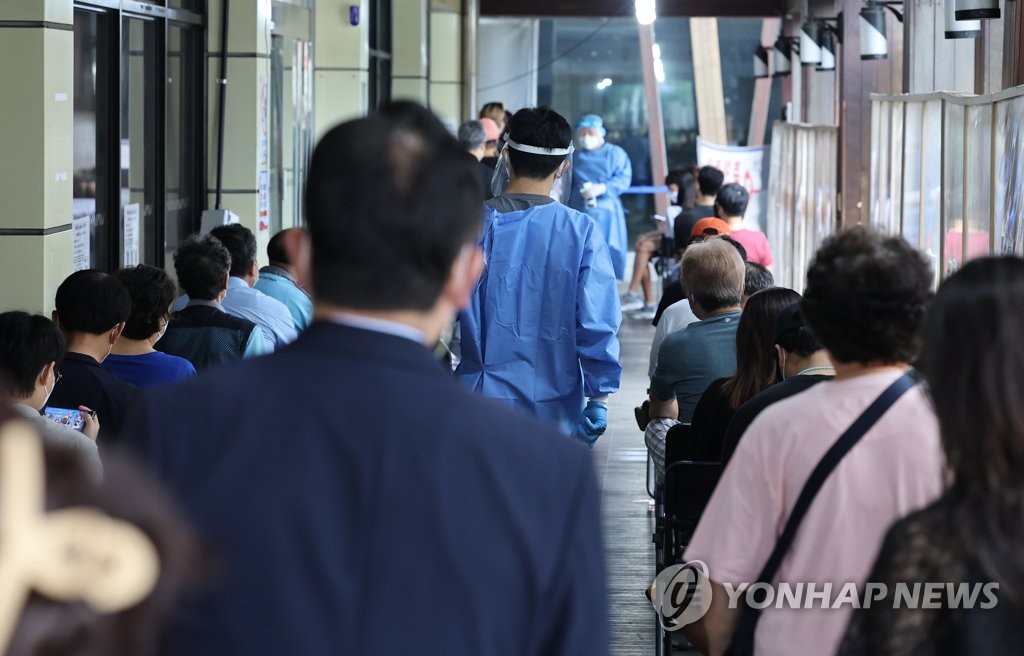 Des citoyens attendent de se faire dépister pour le nouveau coronavirus (Covid-19) au centre médical public de Songpa, dans le sud-est de Séoul, le mercredi 10 août 2022.