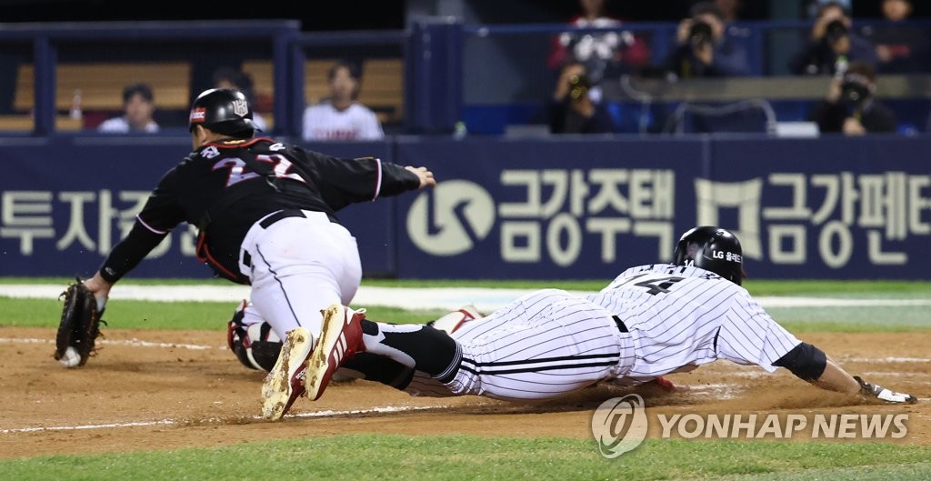 Seo Geon-chang of the LG Twins (R) slides home safely on a sacrifice fly by Chae Eun-seong during the bottom of the ninth inning of a Korea Baseball Organization regular season game against the KT Wiz at Jamsil Baseball Stadium in Seoul on Oct. 11, 2022. (Yonhap)