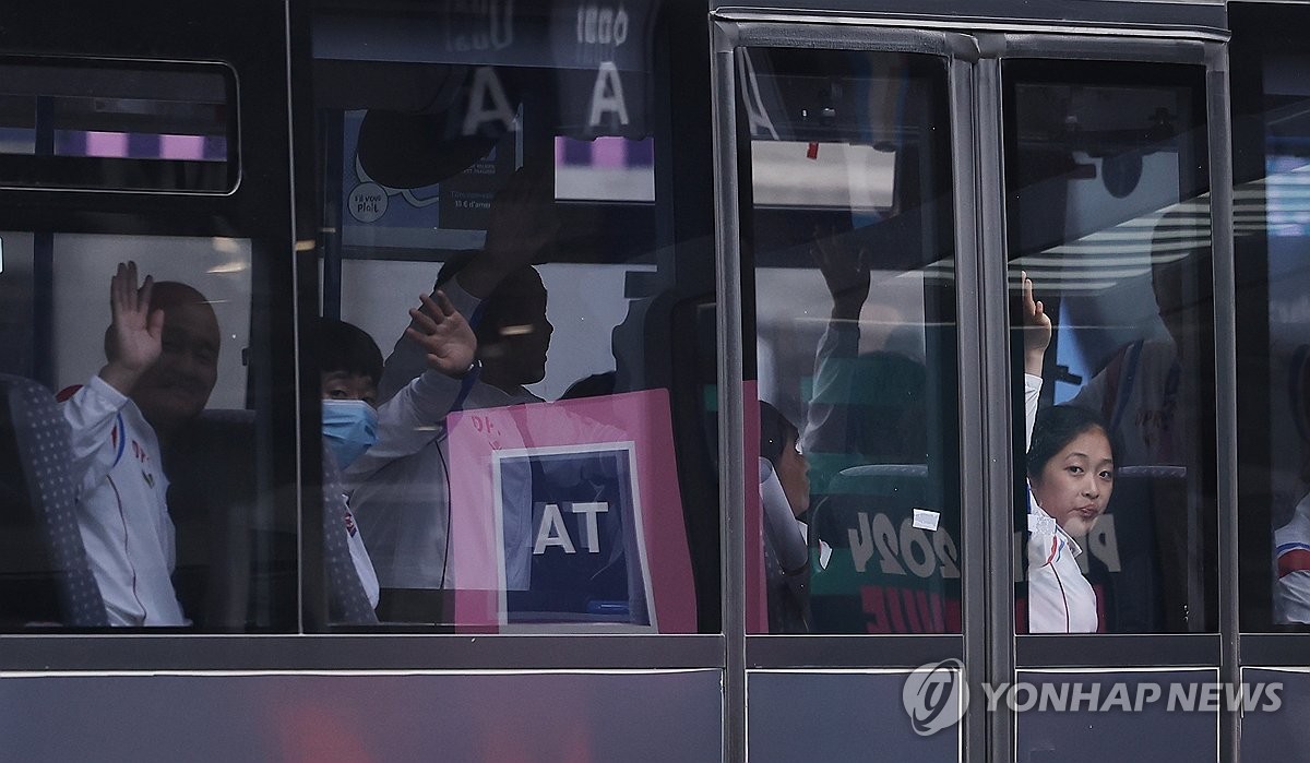 조선-프랑스 친선협회 회원들을 향해 손 흔드는 북한 선수단