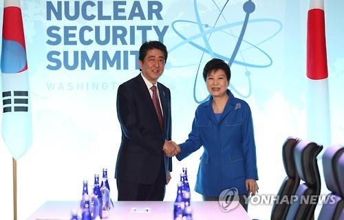 This photo, taken on March 31, 2016, shows President Park Geun-hye shaking hands with Japanese Prime Minister Shinzo Abe before their talks on the sidelines of the National Security Summit in Washington, D.C. (Yonhap)