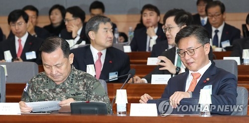 Unification Minister Hong Yong-pyo (R) looks at reports in the government's 2017 policy briefing on defense and diplomatic affairs held at the government complex building in central Seoul on Jan. 4, 2016. (Yonhap)