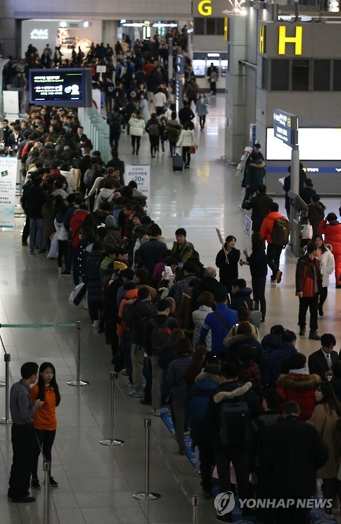 Outbound travelers for the Lunar New year holidays are lined up at a security checkpoint of Incheon International Airport, west of Seoul, on Feb. 5, 2016. (Yonhap)