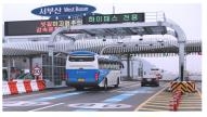 A bus and a passenger car pass through a new overhead highway tolling system without having to reduce their speed in the photo provided by the transportation ministry. (Yonhap)
