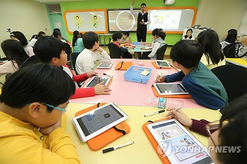 Students use tablets during class at an elementary school in Seoul. (Yonhap file photo)