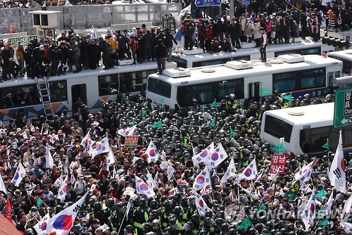 In this photo taken on March 10, 2017, protesters supporting ousted President Park Geun-hye attempt to march towards the Constitutional Court in Seoul after it upheld Park's impeachment. (Yonhap) 