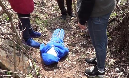 A 53-year-old woman affiliated with a cult group worshiping the dog reenacts her crime on a hill in the southwestern city of Jeonju on April 11, 2017. She has been arrested for allegedly beating to death a 3-year-old boy, who she said was possessed by a demon, in July 2014. (Yonhap) 
