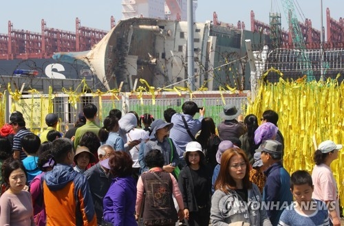 Citizens look at the salvaged Sewol ferry at a port in Mokpo, some 410 kilometers south of Seoul, on April 16, 2017. (Yonhap) 