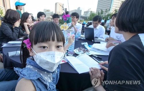 A young girl wearing a mask participates in an event held at Seoul's Gwanghwamun plaza on May 27, 2017, aimed at discussing ways to reduce the level of fine dust. Some 3,000 people, including housewives, children and environmental activists, took part in the event organized by the Seoul Metropolitan Government. (Yonhap)