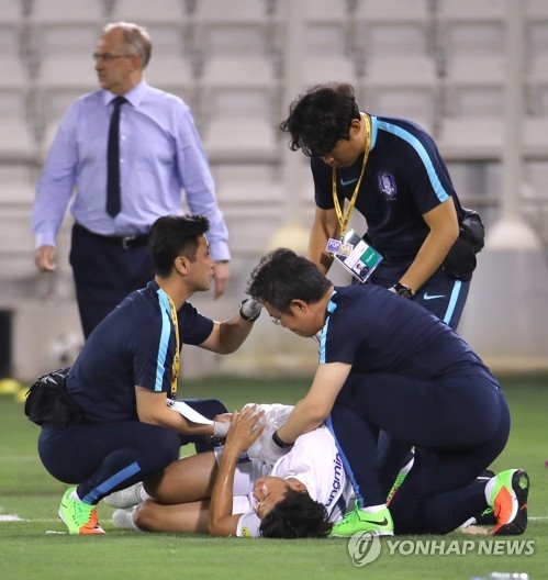 South Korean player Son Heung-min (C) is being treated for an arm injury after an awkward fall during a World Cup qualification match against Qatar at Jassim Bin Hamad Stadium in Doha on June 13, 2017. (Yonhap)