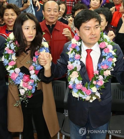 This file photo, taken on April 14, 2016, shows Shim Eun-ha (L), a retired actress, holding hands with her husband Ji Sang-wuk, then a candidate for the Saenuri Party, after he won a parliamentary seat in the general elections. (Yonhap)