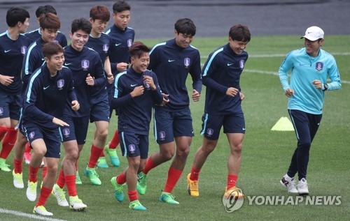 In this file photo taken on May 24, 2017, South Korean football coach Shin Tae-yong (R) runs with the under-20 players during their training in Jeonju, North Jeolla Province. (Yonhap)