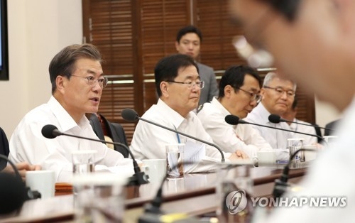 President Moon Jae-in (L) speaks at a weekly meeting with his top aides at Cheong Wa Dae on Oct. 16, 2017. Moon reiterated the need to reduce the country's working hours, noting that long hours not only reduce people's quality of life but also cause unnecessary accidents. (Yonhap) 
