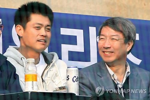 In this file photo taken on April 3, 2011, Chung Un-chan (R), former prime minister named the new commissioner of the Korea Baseball Organization (KBO), attends a KBO regular season game between the Doosan Bears and the LG Twins at Jamsil Stadium in Seoul alongside player-turned-analyst Ahn Kyung-hyun. (Yonhap)