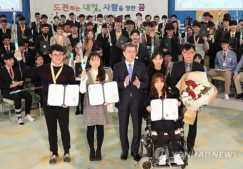 President Moon Jae-in (front row, third from L) poses for a group photo after presenting certificates of scholarship to students in a meeting held at his office Cheong Wa Dae in Seoul on Dec. 28, 2017. (Yonhap)
