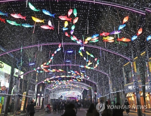 This 2017 file photo shows visitors walking along a street decked with lamps in the shape of "sancheoneo," a type of mountain trout, during the annual Hwacheon Sancheoneo Ice Festival in Hwacheon, 120 kilometers northeast of Seoul. (Yonhap)