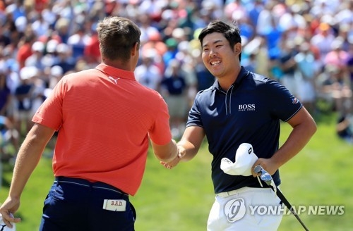 In this Getty Images photo, An Byeong-hun of South Korea (R) shakes hands with Bryson DeChambeau after losing to the American in a playoff at the Memorial Tournament at Muirfield Village Golf Club in Dublin, Ohio, on June 3, 2018. (Yonhap)