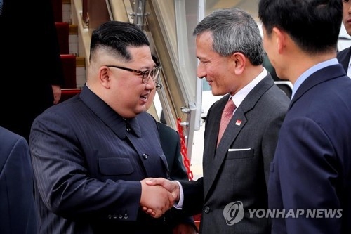 North Korean leader Kim Jong-un (L) shakes hands with Singapore's foreign minister Vivian Balakrishnan on June 10, 2018, after arriving in the city-state for a planned summit with U.S. President Donald Trump, in this photo captured from Balakrishnan's Twitter account. (Yonhap)