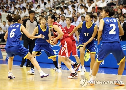 In this Joint Press Corps photo, Ri Jong-ok of North Korea (C, with ball) is surrounded by South Korean players during their friendly basketball game at Ryugyong Chung Ju-yung Gymnasium in Pyongyang on July 5, 2018. (Yonhap)