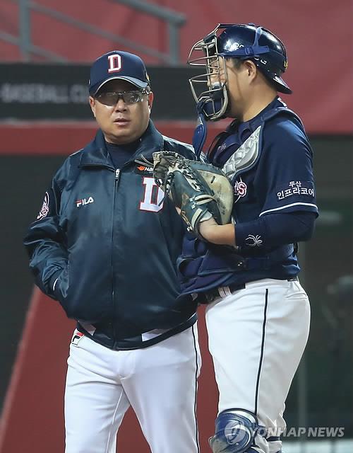 In this file photo from Oct. 26, 2017, Kim Tae-hyung (L), manager of the Doosan Bears, speaks with his catcher Yang Eui-ji during Game 2 of the Korean Series against the Kia Tigers at Gwangju-Kia Champions Field in Gwangju, 330 kilometers south of Seoul. Yang left the Bears via free agency on Dec. 11, 2018, to sign with the NC Dinos. (Yonhap)