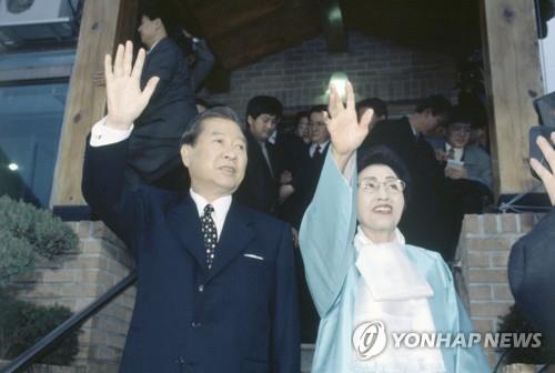 The file photo, taken on Dec. 19, 1997, shows President-elect Kim Dae-jung and his wife, Lee Hee-ho, waving to supporters after winning the presidential election. (Yonhap)