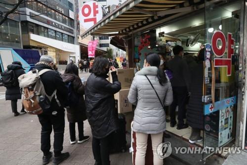 Foreign tourists line up to purchase facial masks at a drug store in Myeongdong, central Seoul, on Jan. 28, 2020. (Yonhap) 