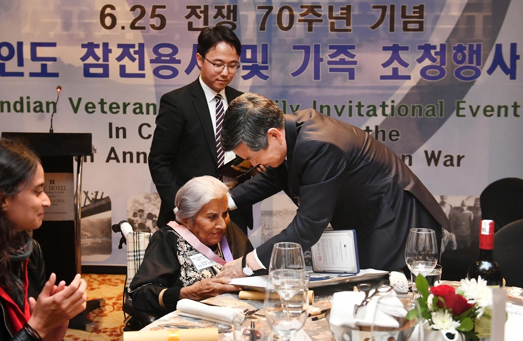 Defense Minister Jeong Kyeong-doo (R) puts "an apostle of peace" medal around the neck of a family member of an Indian veteran who took part in the 1950-53 Korean War during an event for veterans in New Delhi, India, on Feb. 5, 2020, in this photo provided by the defense ministry. (PHOTO NOT FOR SALE) (Yonhap)