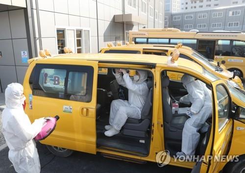 Officials disinfect a kindergarten van in Seoul on Feb. 11, 2020. (Yonhap) 