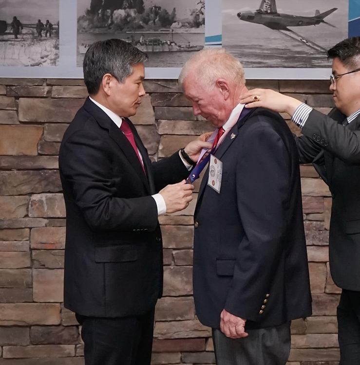 Defense Minister Jeong Kyeong-doo (L) confers a medal on a U.S. veteran of the 1950-53 Korean War during an event at the U.S. Marine Corps Base Camp Pendleton in California on Feb. 26, 2020, in this photo provided by the defense ministry. (PHOTO NOT FOR SALE) (Yonhap)