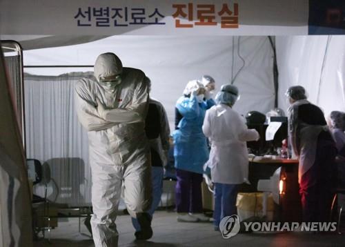 A medical worker shivers in the cold at a special facility set up to treat coronavirus patients at a public hospital in Seoul on March 4, 2020, as the temperature fell to close to 0 C. (Yonhap) 
