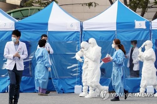 Hospital staff at Bundang Jesaeng Hospital in Seongnam, south of Seoul, prepare to check people with novel coronavirus symptoms at a dedicated screening facility, on March 6, 2020. (Yonhap) 
