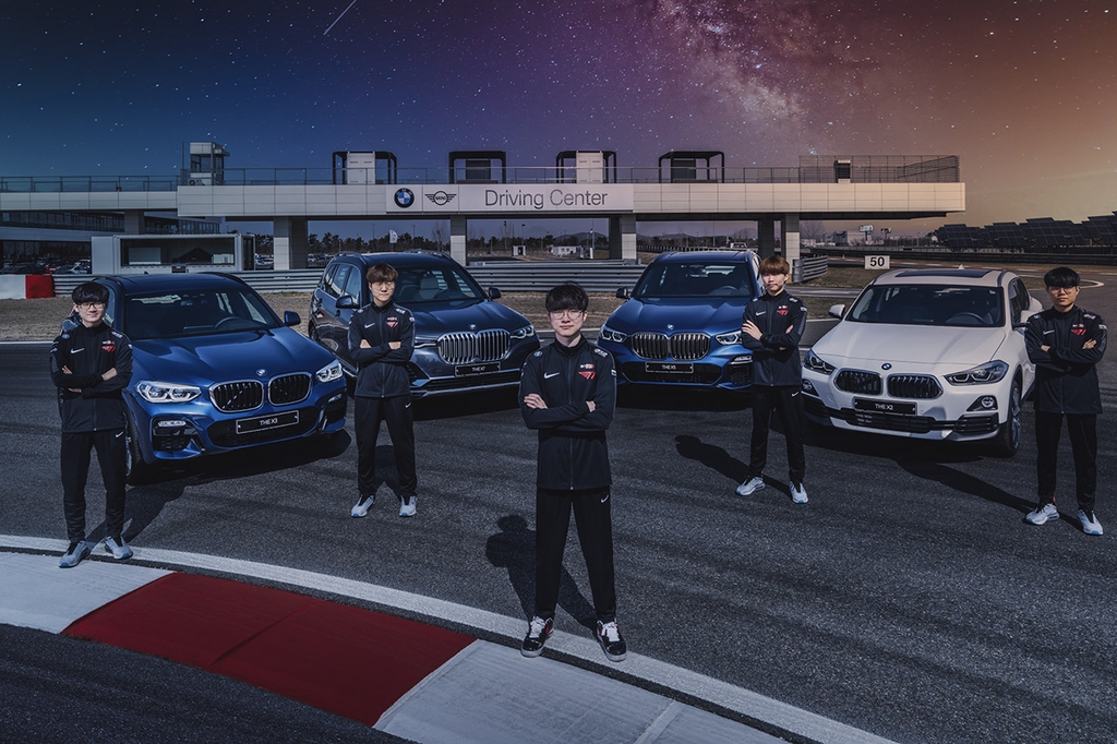 In this photo provided by SK Telecom Co. on April 16, 2020, T1's League of Legends team members pose for a photo with BMW vehicles at BMW Driving Center in Incheon. (PHOTO NOT FOR SALE) (Yonhap)