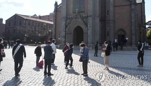 Catholics wait in line while maintaining social distancing to join Mass at Myeongdong Cathedral in Seoul on April 23, 2020. The church reopened for Mass as the government eased social distancing rules amid the persistent slowing of new coronavirus infections. (Yonhap) 