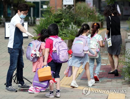 Pupils enter school in Bucheon, Gyeonggi Province, on June 11, 2020. (Yonhap)