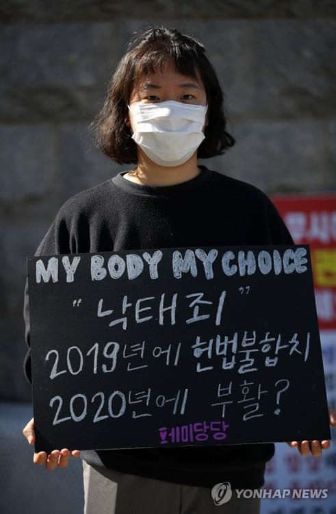 A women's right activist protests in front of the National Assembly on Oct. 7, 2020, calling for the complete abolition of the ban on abortion. (Yonhap)