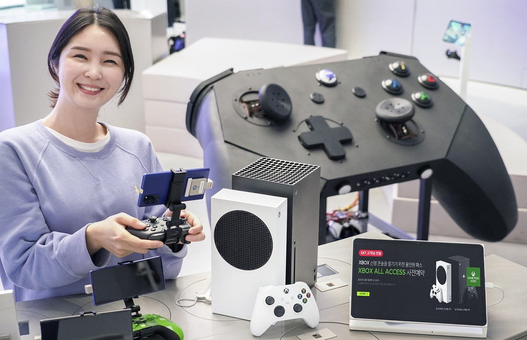 A model poses with the Xbox Series S and the Series X in this photo provided by SK Telecom Co. on Nov. 10, 2020. The carrier launched Microsoft's Xbox All Access service for the South Korean market the same day. (PHOTO NOT FOR SALE) (Yonhap)