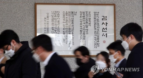 Officials walk by the Oath of Prosecutor posted on the wall at the Seoul Central District Court on Nov. 26, 2020. (Yonhap)