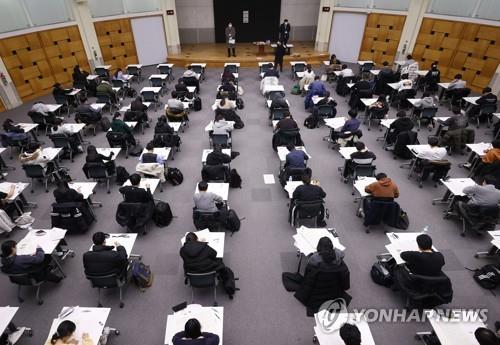 Applicants take an essay test at Konkuk University in Seoul on Dec. 5, 2020, in a follow-up college entrance exam after the state-administrated College Scholastic Ability Test on Dec. 3. They sit apart as a precaution against the coronavirus. (Yonhap)