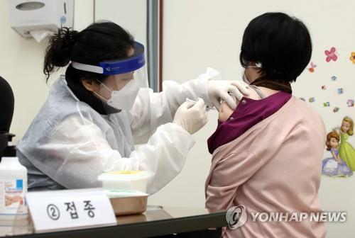A citizen (R) receives a shot of AstraZeneca's COVID-19 vaccine at a public health center in Incheon, 50 km west of Seoul, on Feb. 26, 2021, when the country kicked off its nationwide vaccinations at 9 a.m. More than 5,000 medical workers and patients aged under 65 at long-term care facilities were the vaccine's first recipients. (Yonhap)