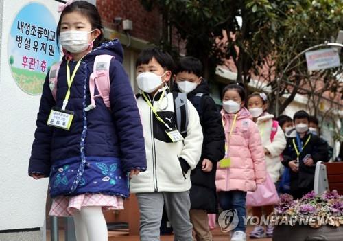 First-graders enter school in a line at Naesung Elementary School in Busan on March 2, 2021. (Yonhap)